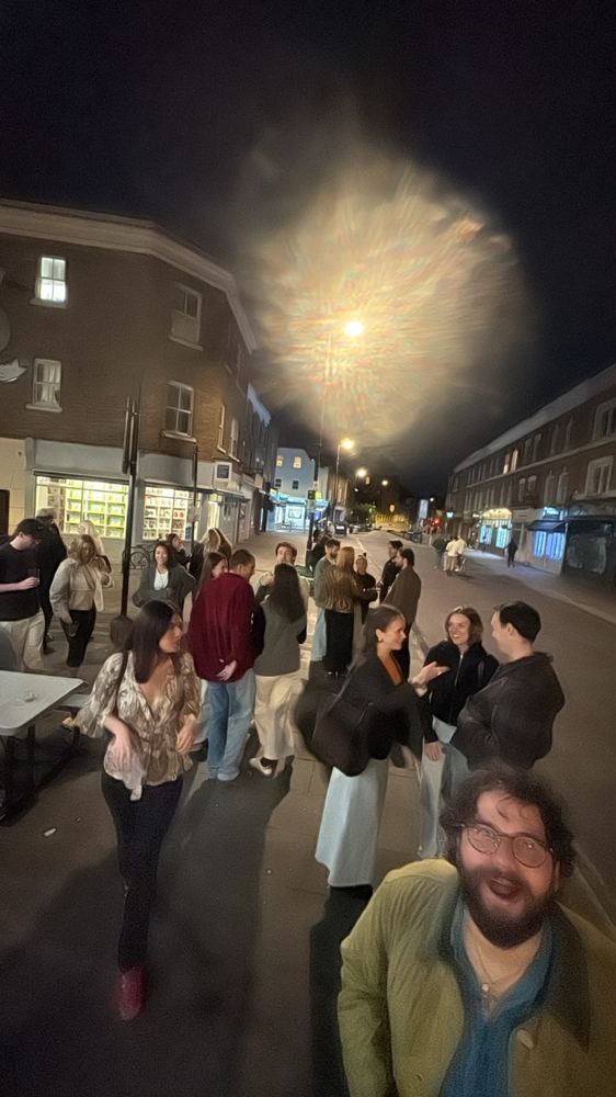 Hunters spilling onto a lamp-lit street at night